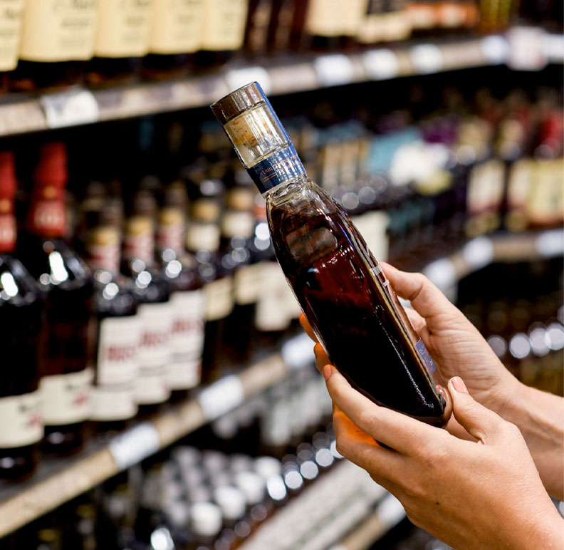 hands holding bottle of liquor in ABC store